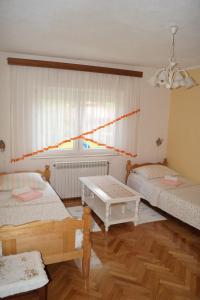 拉科维察Apartment Drago的一间设有两张床和一张桌子的房间