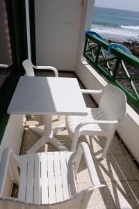 阿列塔SEA & RELAX - Apartament 1 Izq的海滩阳台配有一张白色的桌子和两把椅子