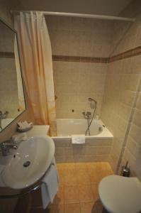 蒙特勒辉煌酒店的一间带水槽、浴缸和卫生间的浴室
