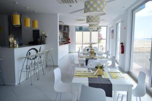 萨尔雷Ouril Hotel Agueda的用餐室配有白色的桌子和白色的椅子