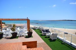 萨尔雷Ouril Hotel Agueda的海滩上带桌椅的阳台