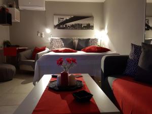 雅典'Romeo & Juliet' Cozy Apartment With Breathtaking View的酒店客房,配有床和鲜花桌