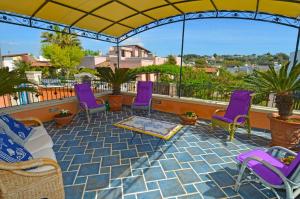 帕图Casa Spano 1 - RosariaVacanze的屋顶上带紫色椅子的庭院