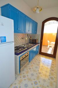帕图Casa Spano 1 - RosariaVacanze的厨房配有蓝色橱柜和白色冰箱