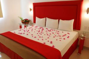 梅里达Hotel Zar Merida的一间卧室,床上有粉红色的鲜花