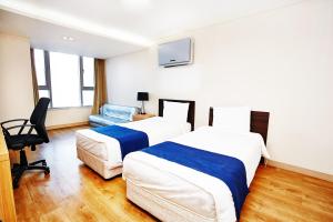 首尔现代住宅的酒店客房,配有两张床和椅子