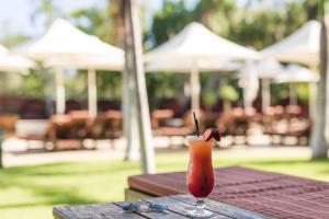 布鲁姆凯布尔海滩俱乐部度假村及水疗中心酒店的坐在木桌边喝一杯
