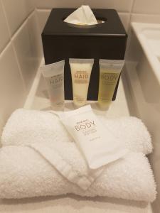 布里斯班布里斯班机场宜必思酒店的浴室提供毛巾和一盒K美容产品