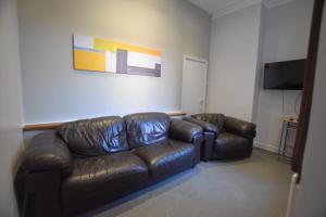 桑德兰Western Hill的客厅配有真皮沙发和电视