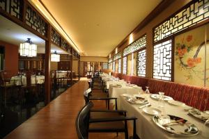 哥印拜陀哥印拜陀塔酒店的用餐室设有长桌子、椅子和窗户。