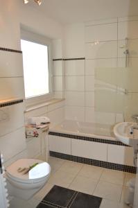 奥托博伊伦潘森莫扎特酒店的浴室配有卫生间、浴缸和水槽。