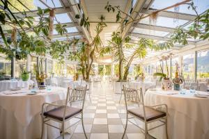 梅拉诺蒂沃利别墅酒店的宴会厅配有桌椅和植物