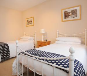 布什米尔斯考特斯摩尔住宿加早餐酒店的一间卧室配有两张白色的床和一盏灯