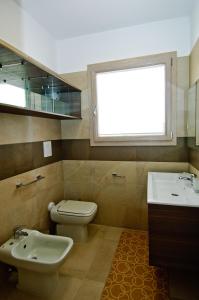 卡斯蒂亚达斯Villa Marianna的一间带卫生间、水槽和窗户的浴室