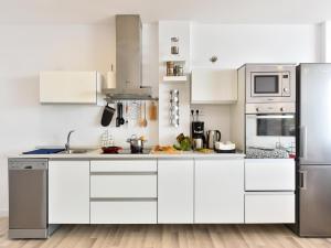 莫甘Penthouse Beyond Amadores的厨房配有白色橱柜和不锈钢用具