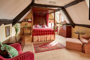 伯福德Burford House BH的一间卧室配有一张红色床罩的床