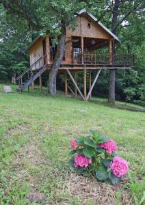 BarilovićTreehouse Resnice -Mrežnica的树屋,有甲板和一些粉红色的花