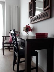 塞尔维诺Appartamento Alba的一张带椅子的黑色桌子和一个花瓶