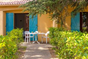 滨海阿热莱斯Azureva Argeles的门廊上的一张桌子和椅子,门廊上设有蓝色的门