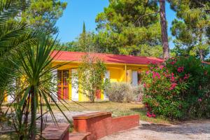 滨海阿热莱斯Azureva Argeles的黄色的房子,有红色的屋顶和一些花