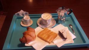 加维Cascina Angela的含糕点和咖啡的蓝色托盘
