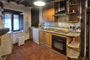Villar de Plasencia卡萨蒂亚艾米利亚酒店的厨房配有水槽和炉灶 顶部烤箱