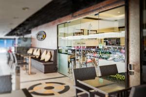 芭堤雅市中心安比恩斯酒店的餐厅设有桌椅和窗户。