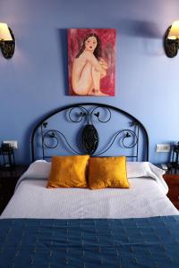 莫哈卡尔阿科广场旅馆的蓝色卧室配有带黄色枕头的床