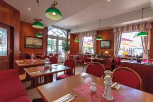 宾茨德意志旗酒店的餐厅设有桌椅和窗户。