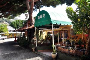 文蒂米利亚罗马露营酒店的一条在街上有绿色遮阳篷的酒吧