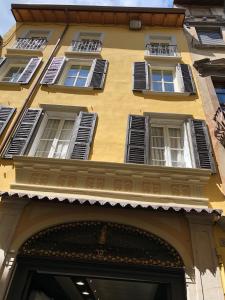 萨罗Casa Collini Salò的黄色的建筑,有白色的窗户和门廊