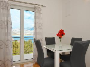 特罗吉尔Apartments Uljevic-close to the beach的一间带桌椅和窗户的用餐室
