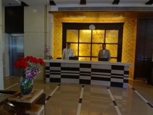 孟买格兰德酒店服务式公寓的两名男子站在大堂的前台