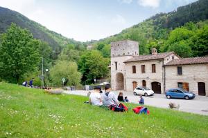 真加Hotel Terme di Frasassi的一群人坐在山上,放风筝