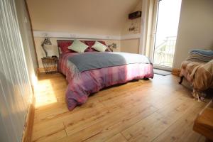 拉斯姆兰McHugh's Loft的一间卧室配有一张床,铺有木地板