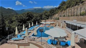 卡托劳塔翁诺斯托斯酒店的一个带遮阳伞和桌椅的游泳池