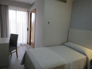 阿兰扎达Hotel La Lanzada的卧室配有床、椅子和窗户。