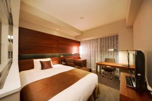 秋田秋田大都会酒店的配有一张床和一张书桌的酒店客房