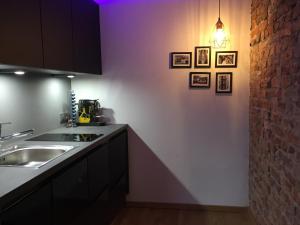 杜塞尔多夫21st Appartement的厨房配有水槽,墙上挂有一些图片
