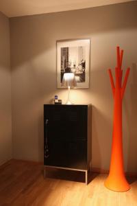 杜塞尔多夫21st Appartement的两只橙色花瓶,坐在带灯的梳妆台上