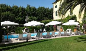 卡夏纳泰尔梅罗马阿尔伯格酒店的一组椅子和遮阳伞,位于游泳池旁