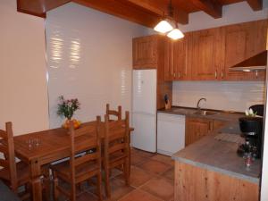 Bernúy-Salinero厄尔多尔蒙乡村民宿的厨房配有木桌、椅子和水槽