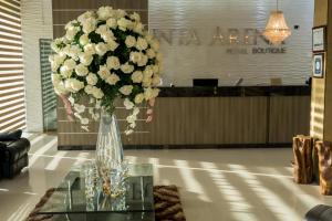 阿劳卡Hotel Punta Arena Spa Boutique的玻璃桌上满是白色花的花瓶