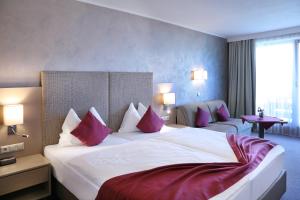 沃尔特湖畔韦尔登Dei Hotel Schönblick的酒店客房配有一张带红色枕头的大床