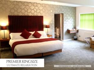 布莱克浦罗斯金酒店的一间卧室配有一张大床和红色床头板
