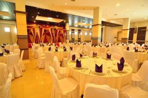 吉打邦ASTON Ketapang City Hotel的宴会厅配有白色的桌子和白色的椅子