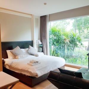华欣Residence Nithiwat Amri Hua Hin的一间卧室设有一张床和一个大窗户