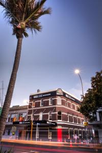 奥克兰哈卡小屋奥克兰旅舍的一条街道旁的棕榈树建筑