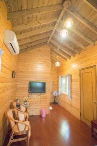鹿谷乡翠谷山莊Cui Gu Villiage的木墙、电视和椅子的房间