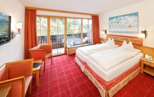 莱赫阿尔贝格莱赫及樵萨罗莎酒店的酒店客房设有一张大床和一个阳台。